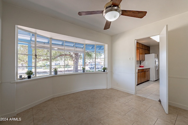 spare room with light tile patterned floors, ceiling fan, and plenty of natural light