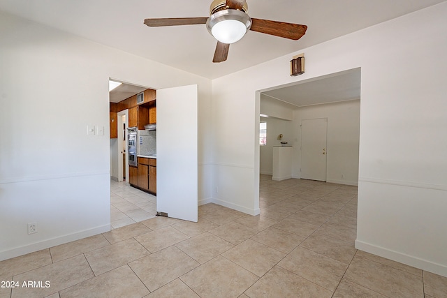 empty room with ceiling fan and light tile patterned flooring