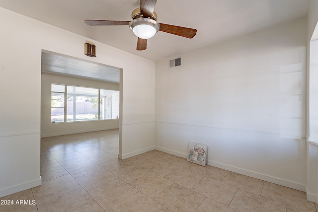 tiled spare room featuring ceiling fan