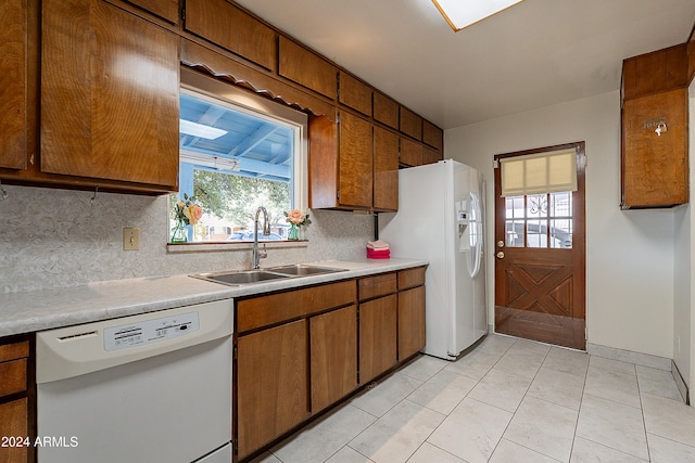 kitchen with tasteful backsplash, white appliances, sink, and plenty of natural light