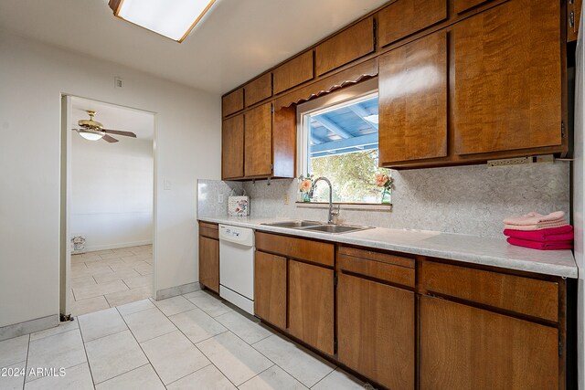 kitchen featuring tasteful backsplash, light tile patterned flooring, sink, dishwasher, and ceiling fan