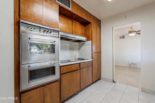 kitchen featuring black electric cooktop, ceiling fan, light tile patterned floors, stainless steel double oven, and range hood