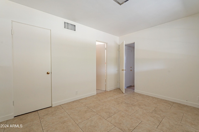 unfurnished bedroom featuring a closet and light tile patterned flooring