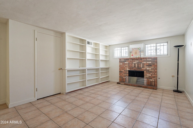 unfurnished living room with a brick fireplace and light tile patterned floors