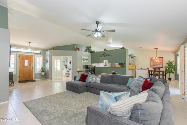 living area featuring lofted ceiling, light tile patterned floors, and ceiling fan