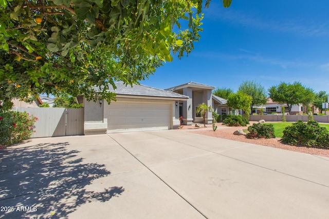 ranch-style home featuring fence, concrete driveway, stucco siding, and a garage