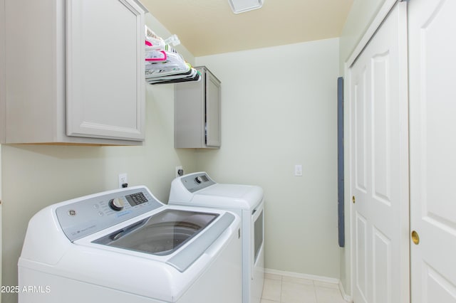 laundry room featuring light tile patterned floors, baseboards, cabinet space, and washing machine and dryer