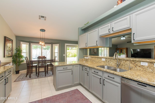 kitchen featuring light tile patterned floors, a sink, visible vents, dishwasher, and hanging light fixtures