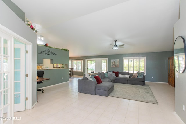 living area featuring lofted ceiling, french doors, ceiling fan, and baseboards