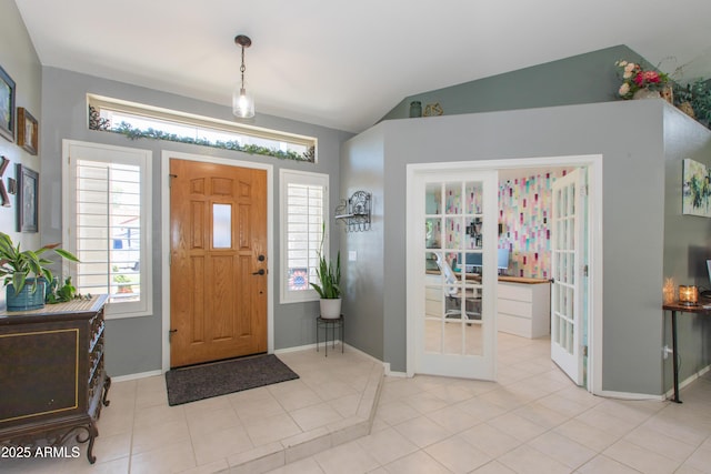 foyer entrance featuring baseboards and lofted ceiling
