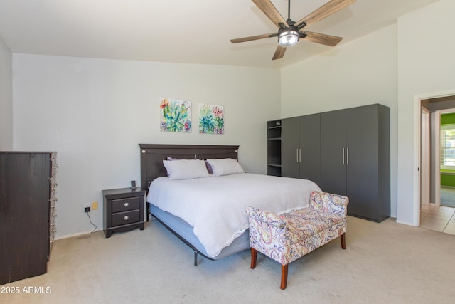 bedroom with lofted ceiling, ceiling fan, light carpet, and baseboards