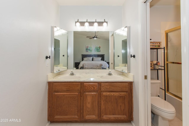 ensuite bathroom featuring ceiling fan, connected bathroom, double vanity, and a sink