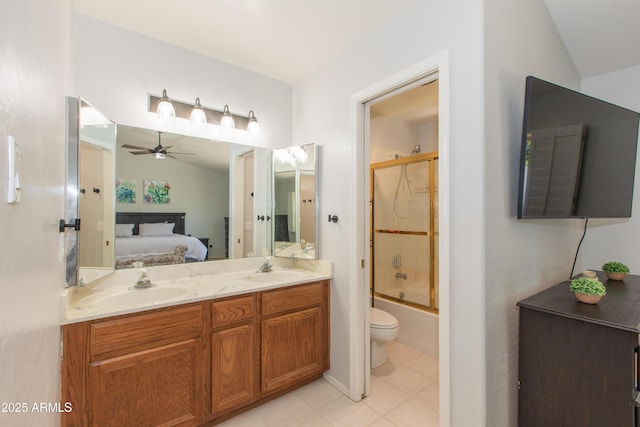 ensuite bathroom featuring connected bathroom, tile patterned floors, vaulted ceiling, ceiling fan, and a sink