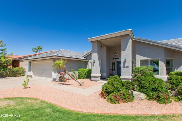 view of front of house with a tiled roof, stucco siding, concrete driveway, and an attached garage