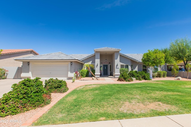 view of front of house featuring stucco siding, a garage, a tile roof, a front yard, and concrete driveway