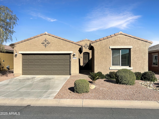 view of front of property featuring concrete driveway, an attached garage, and stucco siding