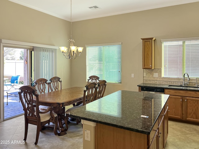 dining room with a chandelier, light tile patterned floors, and crown molding