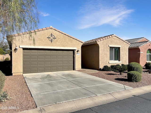 view of front of property featuring driveway, a tiled roof, an attached garage, and stucco siding