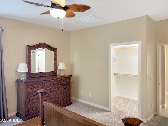 bedroom featuring visible vents, a spacious closet, a ceiling fan, light carpet, and baseboards