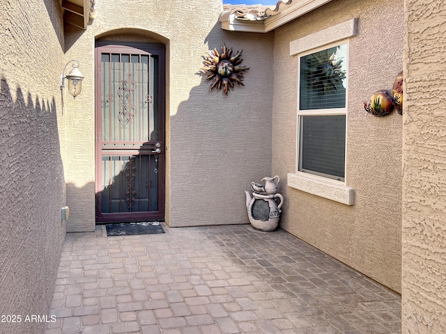 entrance to property with a tiled roof and stucco siding