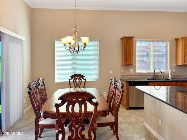 dining area featuring light tile patterned floors, crown molding, baseboards, and a notable chandelier