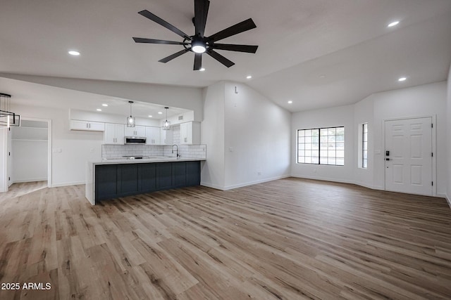 619 N Norfolk, Mesa, AZ 85205 - unfurnished living room with lofted ceiling, light wood finished floors, a ceiling fan, a sink, and recessed lighting
