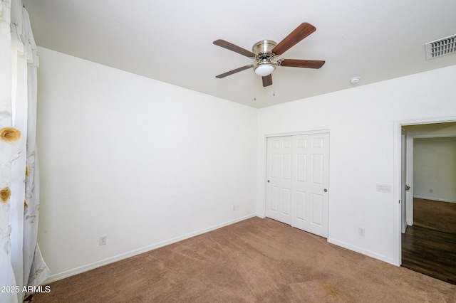 unfurnished bedroom with carpet flooring, ceiling fan, and a closet