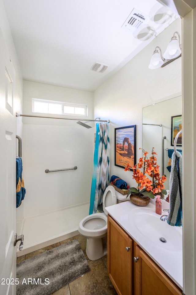 bathroom featuring vanity, toilet, and walk in shower