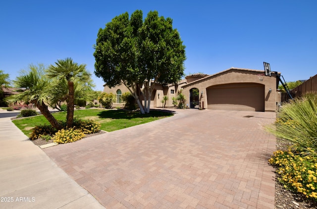 9842 E Celtic Dr, Scottsdale, AZ 85260 - mediterranean / spanish house with decorative driveway, a garage, stucco siding, and a front lawn