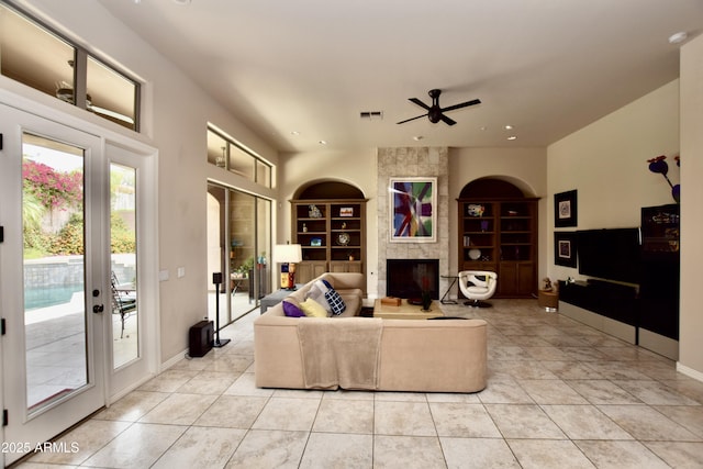 9842 E Celtic Dr, Scottsdale, AZ 85260 - living area with built in features, a tiled fireplace, ceiling fan, light tile patterned flooring, and recessed lighting