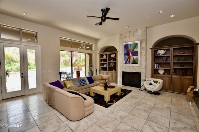 9842 E Celtic Dr, Scottsdale, AZ 85260 - tiled living room with a ceiling fan, built in features, recessed lighting, a tiled fireplace, and french doors