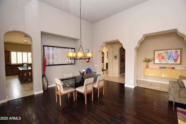 9842 E Celtic Dr, Scottsdale, AZ 85260 - dining area featuring arched walkways, wood finished floors, baseboards, and a chandelier