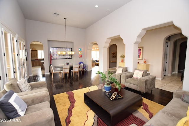 9842 E Celtic Dr, Scottsdale, AZ 85260 - living room featuring arched walkways, a chandelier, and hardwood / wood-style floors
