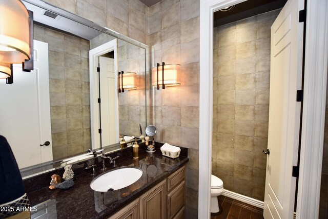 9842 E Celtic Dr, Scottsdale, AZ 85260 - bathroom featuring tile walls, toilet, vanity, and wood finished floors