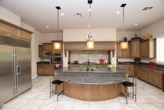 9842 E Celtic Dr, Scottsdale, AZ 85260 - kitchen featuring built in appliances, decorative backsplash, a breakfast bar, light tile patterned floors, and recessed lighting