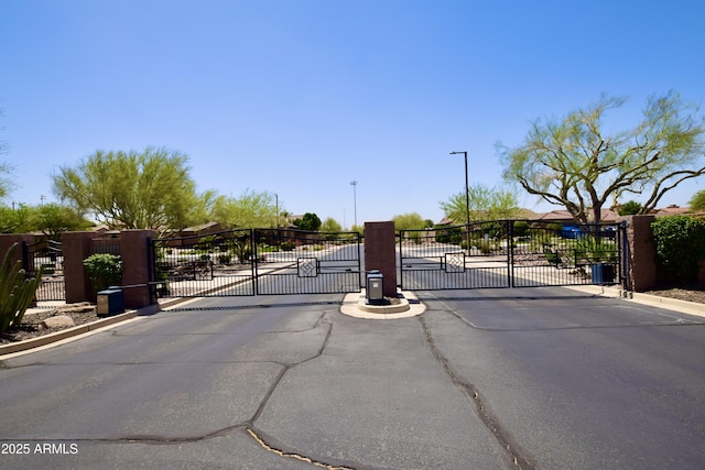 9842 E Celtic Dr, Scottsdale, AZ 85260 - view of asphalt road with a gate, a gated entry, street lights, and curbs