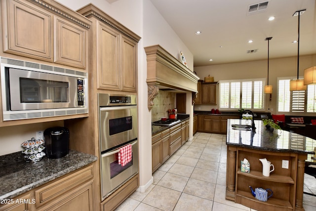 9842 E Celtic Dr, Scottsdale, AZ 85260 - kitchen with appliances with stainless steel finishes, a sink, dark stone countertops, light tile patterned floors, and decorative backsplash