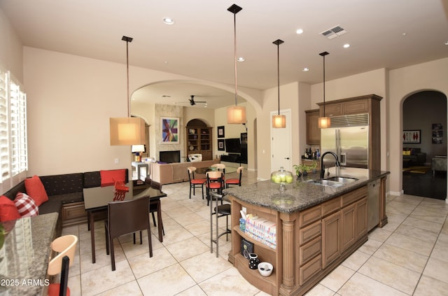 9842 E Celtic Dr, Scottsdale, AZ 85260 - kitchen featuring appliances with stainless steel finishes, arched walkways, a sink, light tile patterned floors, and recessed lighting