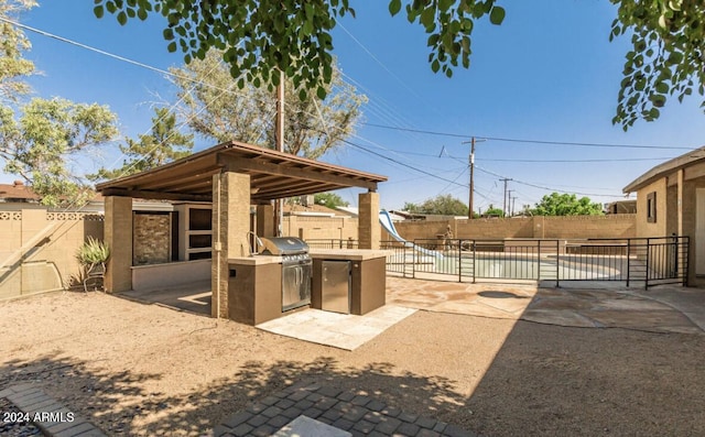 5850 W Cheery Lynn Rd, Phoenix, AZ 85031 - view of patio featuring grilling area, an outdoor kitchen, and a fenced backyard