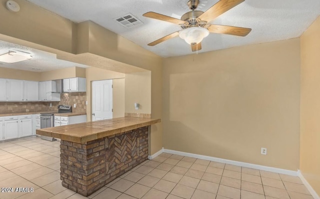 5850 W Cheery Lynn Rd, Phoenix, AZ 85031 - kitchen with stainless steel electric range, light tile patterned floors, white cabinetry, backsplash, and visible vents