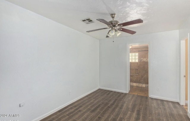 spare room featuring dark wood-type flooring and ceiling fan