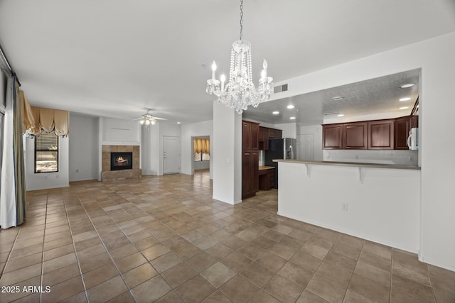 19700 N 76th St Unit 1103, Scottsdale, AZ 85255 - kitchen featuring open floor plan, ceiling fan, a peninsula, a breakfast bar, and a tiled fireplace