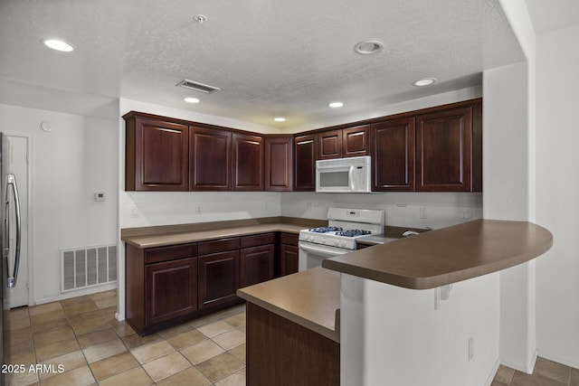 19700 N 76th St Unit 1103, Scottsdale, AZ 85255 - kitchen with white appliances, a peninsula, a textured ceiling, recessed lighting, and a breakfast bar