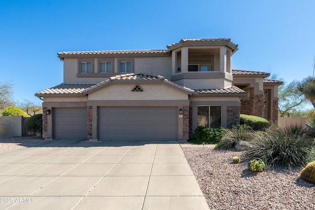 mediterranean / spanish home with stucco siding, stone siding, a garage, and concrete driveway