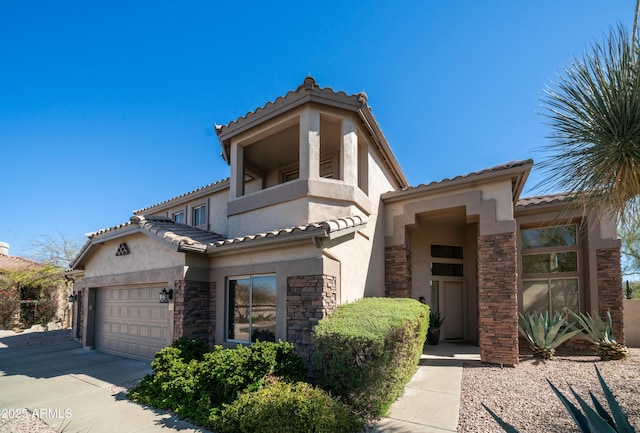 mediterranean / spanish house featuring a garage, stone siding, concrete driveway, and stucco siding