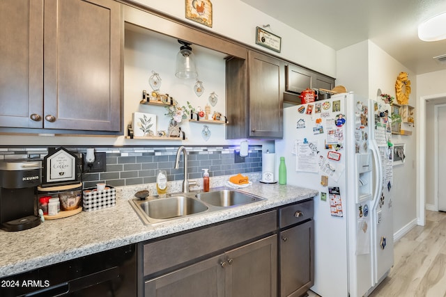 kitchen with white fridge with ice dispenser, dark brown cabinets, backsplash, sink, and light wood-type flooring