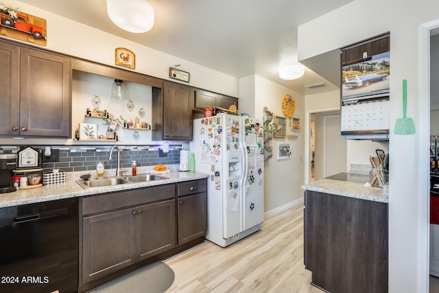 kitchen featuring white fridge with ice dispenser, tasteful backsplash, sink, light wood-type flooring, and dishwasher