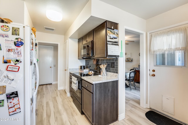 kitchen featuring white fridge, light hardwood / wood-style floors, dark brown cabinets, and black range with electric stovetop