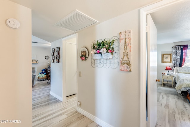 corridor with light hardwood / wood-style floors