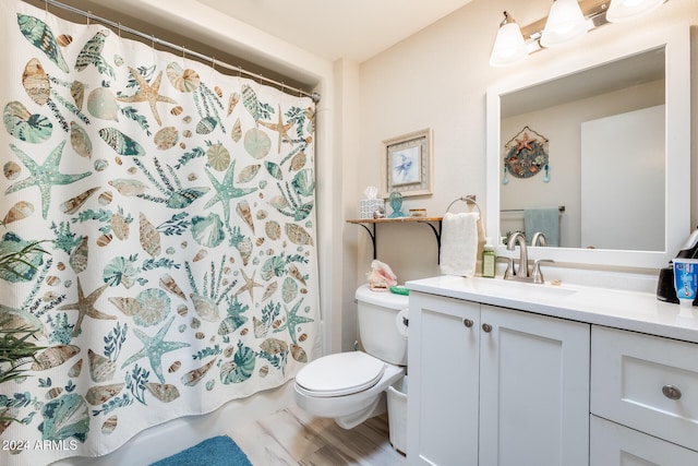 bathroom featuring toilet, walk in shower, hardwood / wood-style flooring, and vanity